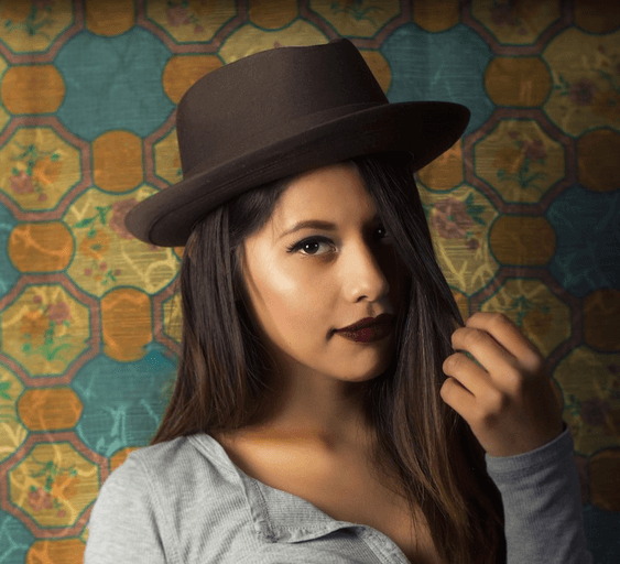 a young woman wearing a hat looking at the camera